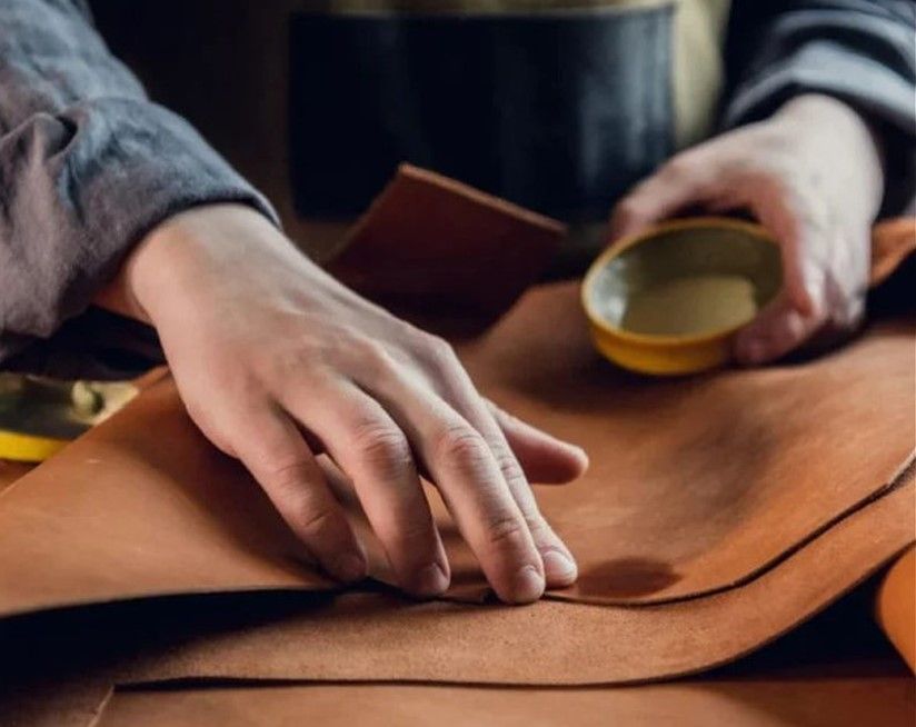 Artisan’s hands working with premium leather, highlighting traditional craftsmanship, material texture, and attention to detail.