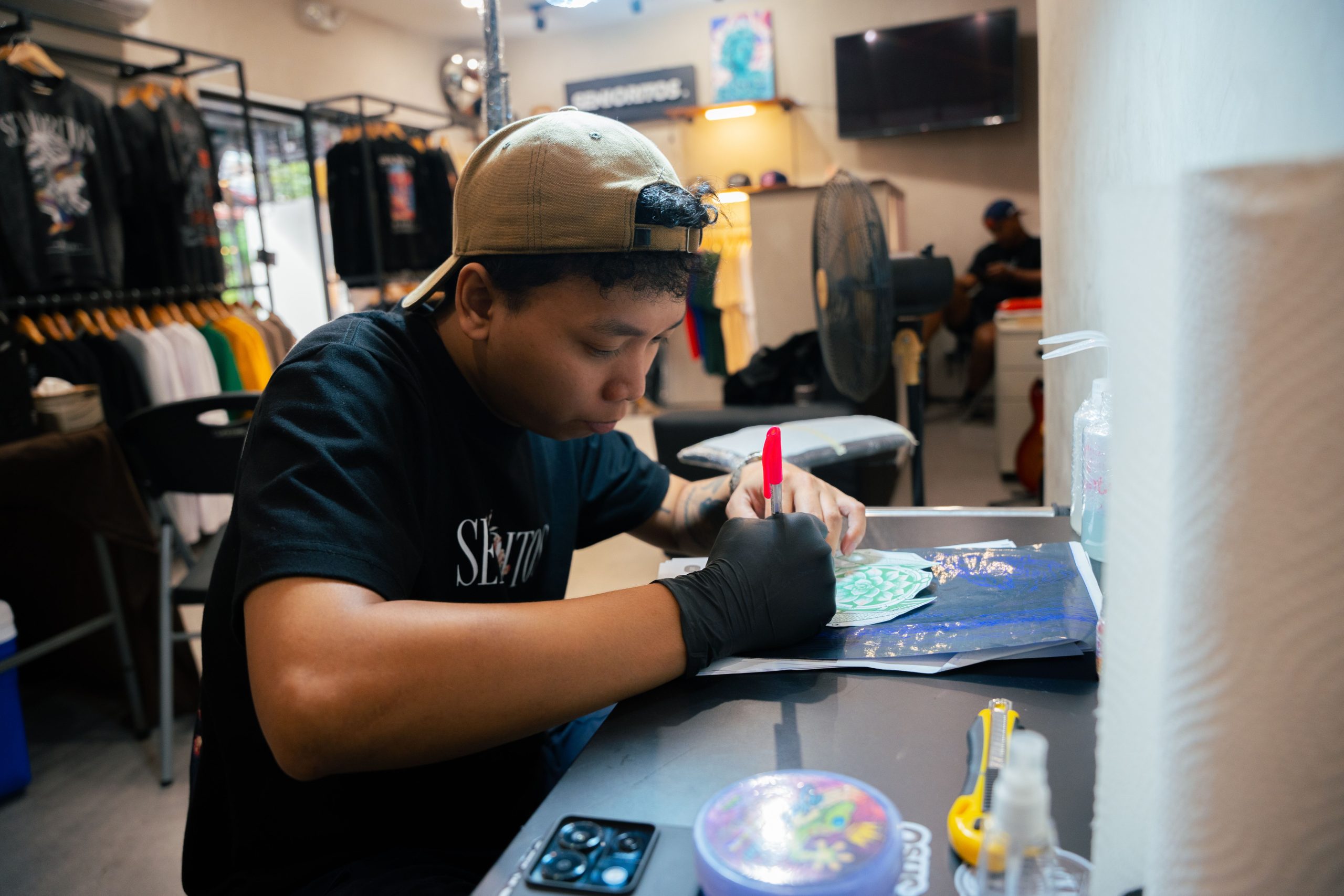 Artist creating a colorful custom T-shirt design in a studio